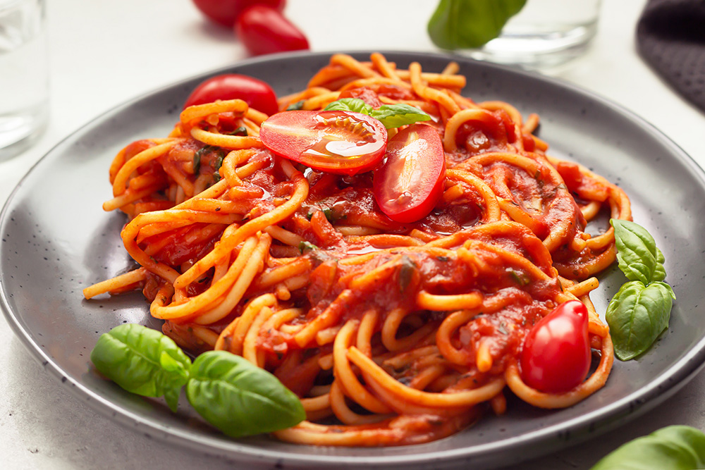 Spaghetti with red sauce, grape tomatoes, and basil